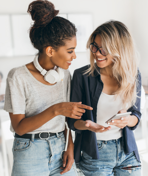 Young girl holding a smartphone while talking with colleague in office.